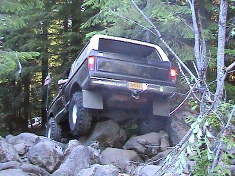 1978 Ford Bronco - This 1978 Ford Bronco navigates a rocky trail, showing its rear end and off-road capabilities.