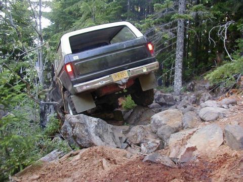 1978 Ford Bronco - This 1978 Ford Bronco is shown off-roading on a steep, rocky path surrounded by trees.