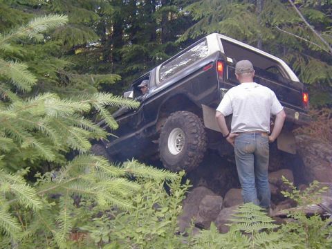 1978 Ford Bronco - This off-road vehicle navigates a rocky trail, with a person observing its progress.