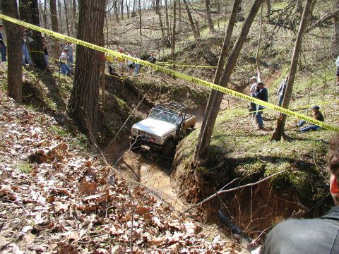 1992 Ford Bronco - An off-road SUV navigates a challenging muddy terrain during an event.