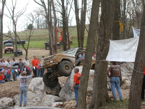 1992 Ford Bronco - A vintage Ford Bronco navigates a challenging off-road obstacle course with spectators observing.