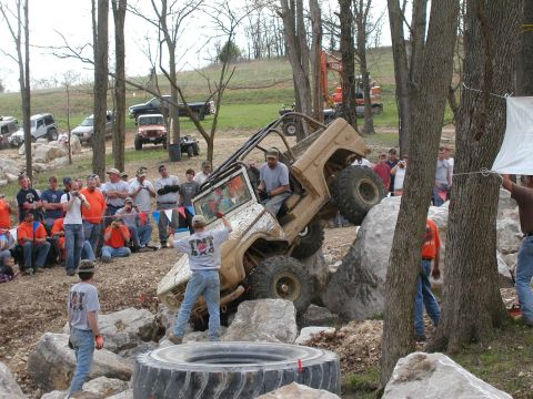 1992 Ford Bronco - An off-road vehicle navigates a challenging rocky course with spectators watching.