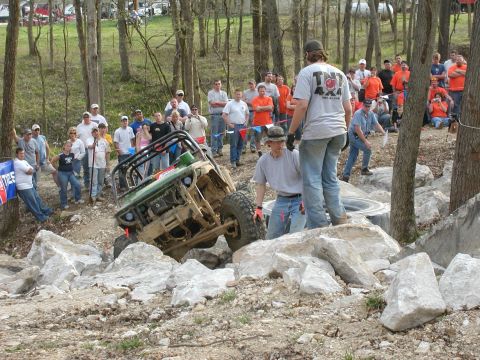 1992 Ford Bronco - Spectators watch an off-road vehicle attempt to navigate a rocky obstacle course.