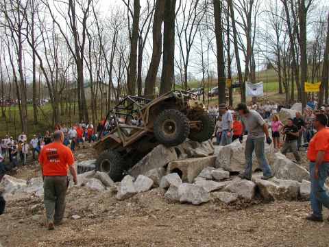 1992 Ford Bronco - A custom-built off-road buggy navigates a challenging rock obstacle course with spectators observing.