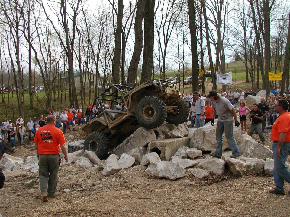 Off-road buggy on rocks with crowd watching. Text on orange shirt says 'The Ohio Trail Guides'