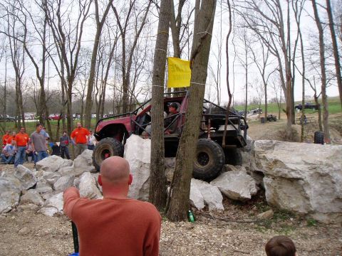 1992 Ford Bronco - An off-road vehicle attempts to traverse a rocky obstacle course with onlookers present.