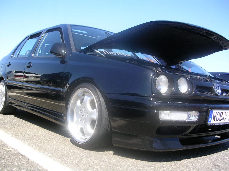 Black sedan with hood open, custom wheels, and a license plate reading WOB-V