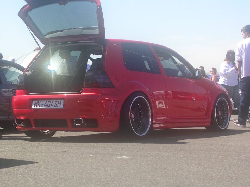 red hatchback with trunk open, custom wheels, and aftermarket body kit. License plate reads MK-4GASM