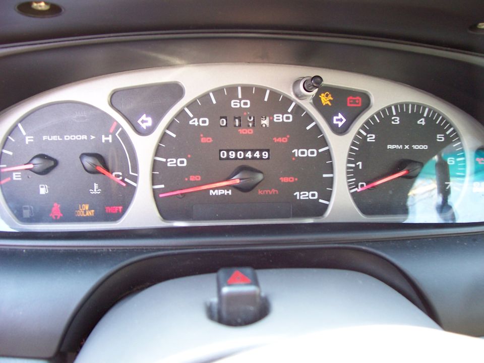 Dashboard with speedometer, tachometer, fuel gauge, and warning lights. Odometer shows 090449