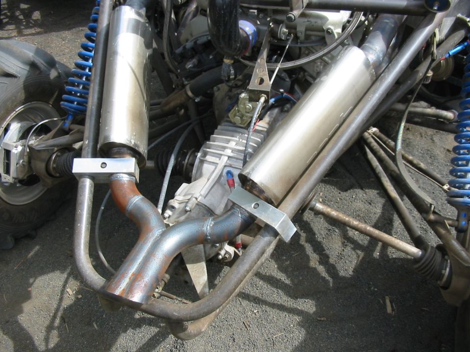 Twin stainless exhaust canisters and aluminum transaxle on a tube-frame buggy with blue coil-overs