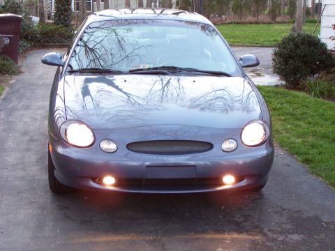 1999 Ford Taurus - Front view of a gray 1999 Ford Taurus parked on a driveway.