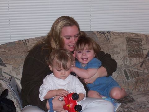 1983 Ford Bronco - A woman sits on a couch with two children, one of whom is playing with a toy truck.