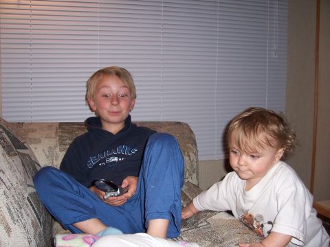 1983 Ford Bronco - Two young boys are relaxing on a couch, one holding a flip phone and the other reaching out.