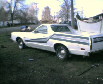 1977 Ford Ranchero - White 1977 Ford Ranchero parked on grass with hood open.