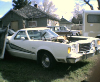 1977 Ford Ranchero - A white 1977 Ford Ranchero is parked outside with its hood open, showing the engine compartment.
