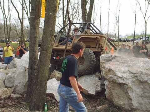 1992 Ford Bronco - Off-road vehicle attempts to climb over large rocks with spectators present.