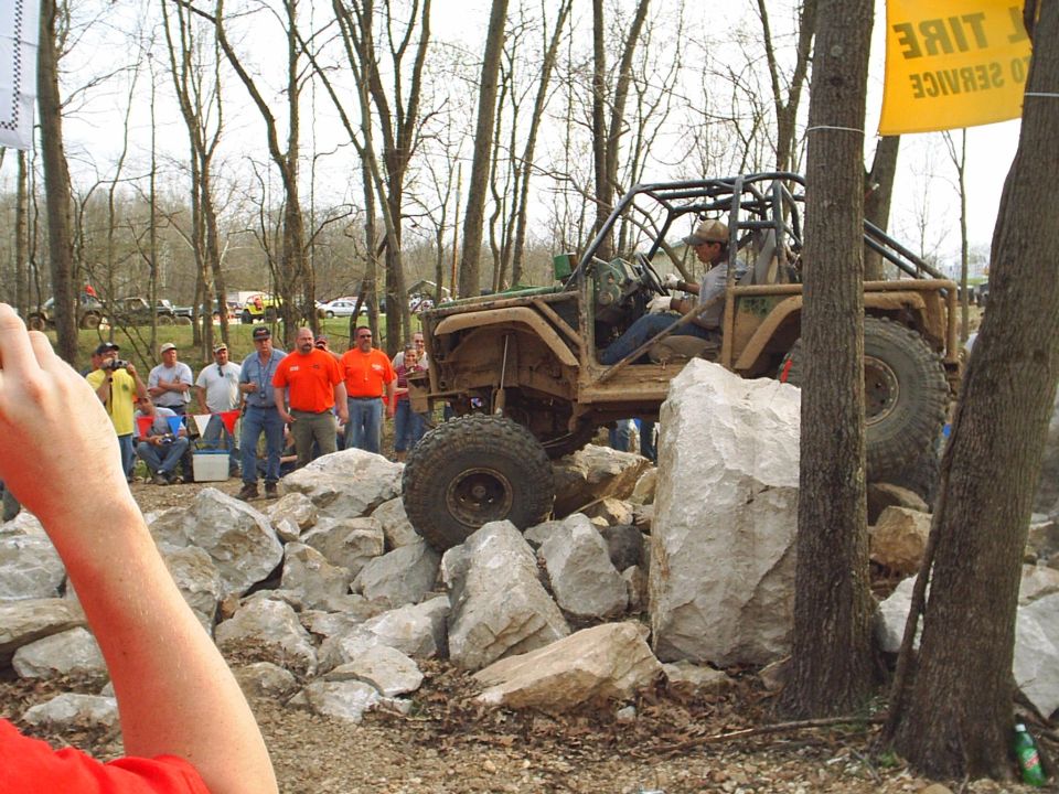 Modified off-road vehicle with a roll cage navigating a rocky terrain