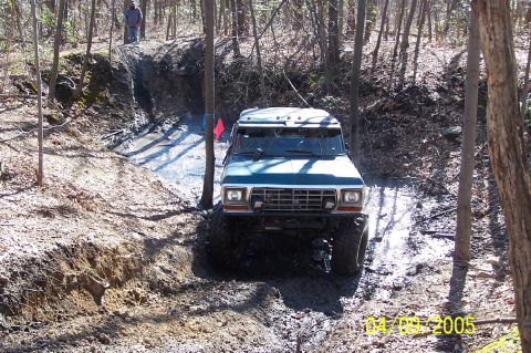 1979 Ford Bronco - This vehicle navigates a challenging muddy terrain in a wooded area.
