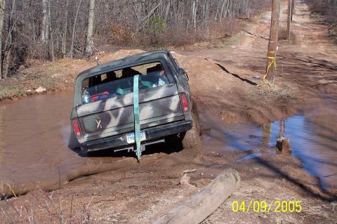 1979 Ford Bronco - Camouflaged 1979 Ford Bronco navigates a muddy off-road trail.