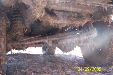1979 Ford Bronco - The heavily soiled undercarriage of an off-road vehicle is shown, obscuring specific details.