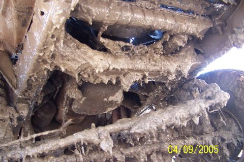 1979 Ford Bronco - Thick mud covers the undercarriage, making identification difficult. The Supermotors.net logo is visible in the lower right corner.