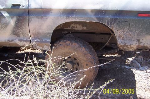 1979 Ford Bronco - Muddy 1979 Ford Bronco rear wheel and fender detail, seen off-road.