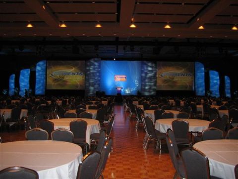 1994 Ford Bronco - A large conference hall is set up with numerous round tables and a stage a "Comments" presentation.