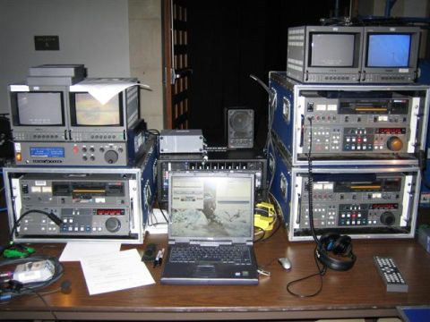 1994 Ford Bronco - A collection of video production equipment, including multiple monitors, audio equipment, and a laptop, is set up on a table.