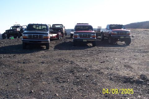 1979 Ford Bronco - Multiple Ford trucks are parked in an outdoor area under a clear sky.
