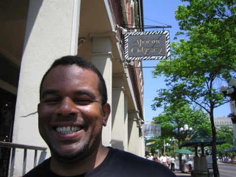 1994 Ford Bronco - A man smiles broadly in front of a building with a sign for 'African Odyssey'.
