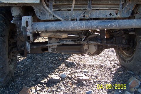 1979 Ford Bronco - Close-up view of the front axle and suspension system of a vehicle, showing its heavy-duty components.