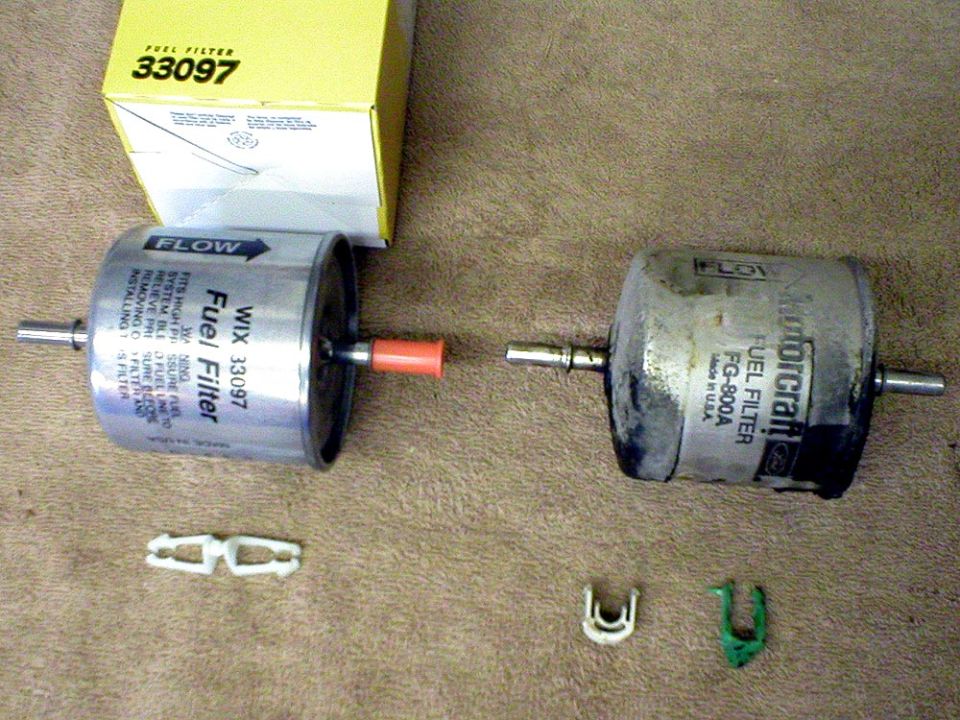 Here’s a comparison of the old and new filters and hardware.
I chose a WIX #33097 to install.
Note, the WIX filter has two of the same type of clips, while the factory filter has two different ones.
Either type will work, though I did decide to re-use the white factory clip, as it has a larger contact area.