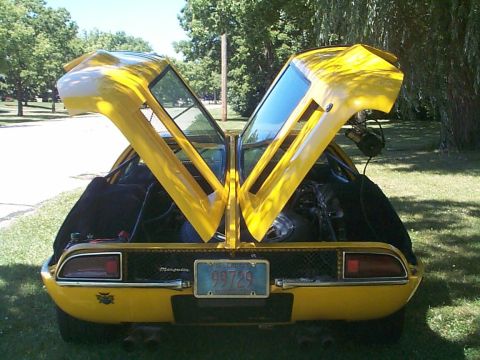 1968 Ford Mustang - This yellow sports car features distinctive gullwing doors that are open, revealing the engine compartment. The rear view shows a license p…