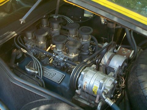 1968 Ford Mustang - Close-up of a V8 engine bay, multiple carburetors and an AC compressor. The "OMASO" marking is visible on the engine block.