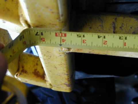 1979 Ford Bronco - A tape measure is used to measure a section of yellow painted metal, likely part of a vehicle frame.