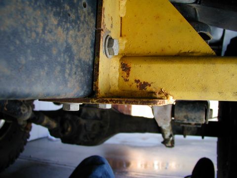 1979 Ford Bronco - Underside view of vehicle frame and suspension components, showing bolted connections and rust.