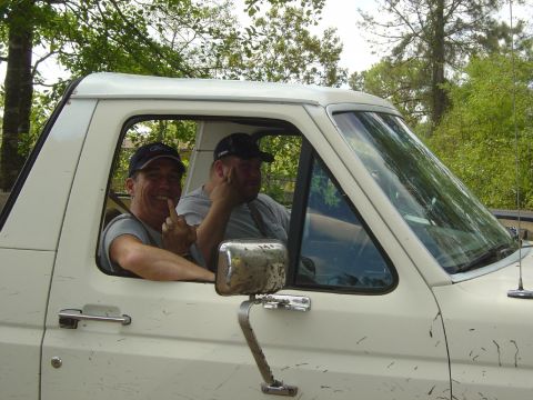 1993 Ford Bronco - Two men are inside a white pickup truck, with one giving the middle finger to the camera.