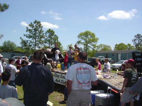 1993 Ford Bronco - An outdoor event is underway with attendees and vehicles present, possibly a car club gathering.