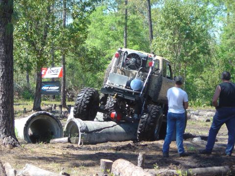 1993 Ford Bronco - An off-road vehicle attempts to traverse a challenging obstacle course in a wooded area.
