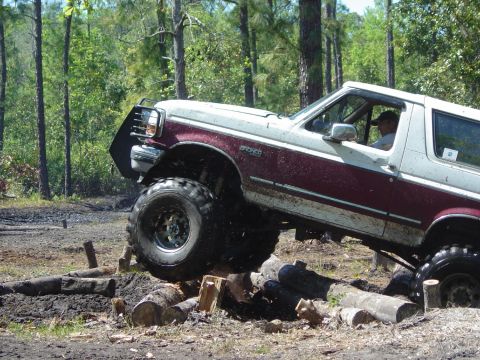 1993 Ford Bronco - A modified Ford Bronco tackles a challenging off-road course made of logs.