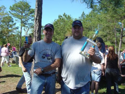 1993 Ford Bronco - Two men pose with trophies at an outdoor event, possibly a competition or celebration.