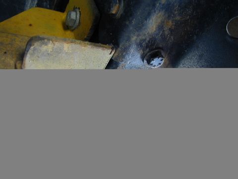 1979 Ford Bronco - Detail shot of aged metal components, showing rust and yellow paint with visible bolts.