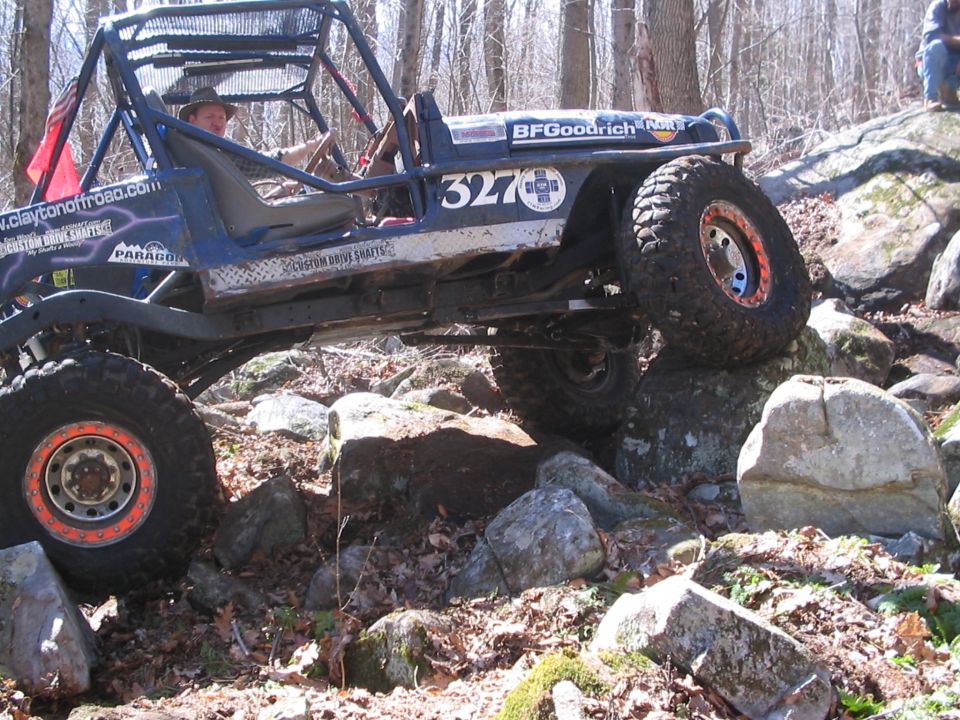 Off-road buggy with roll cage and BFGoodrich tires navigating rocky terrain