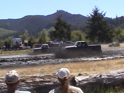 1978 Ford Bronco - Several trucks are seen participating in a mud bogging event with spectators watching from the side.