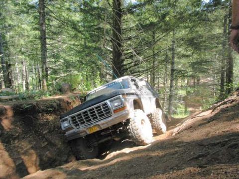 1978 Ford Bronco - This 1978 Ford Bronco is tackling a challenging off-road course in a forest.