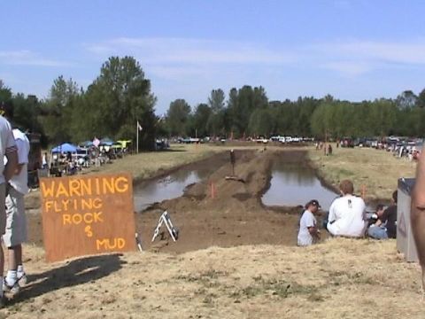 1978 Ford Bronco - A mud drag race event is underway with spectators watching from the sidelines.