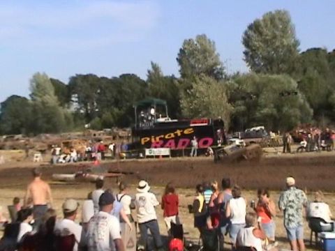 1978 Ford Bronco - Spectators watch as a vehicle struggles in the mud during a drag race event, with a large trailer labeled 'Pirate Radio' in the background.