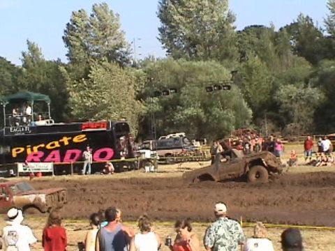 1978 Ford Bronco - Mud drag race event with a truck stuck in the mud and a Pirate Radio bus.