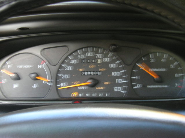 Car dashboard with speedometer, fuel gauge, and tachometer visible. Odometer reads 088606