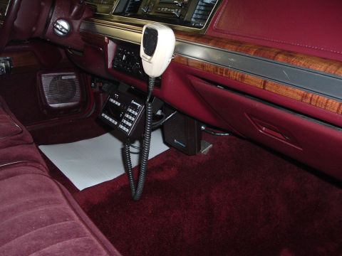 2001 Ford Crown Victoria - The interior of a car features a maroon color scheme and a CB radio with a microphone.
